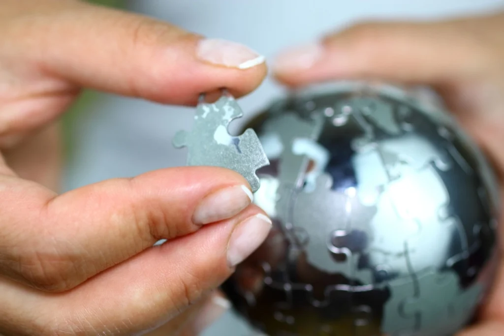 woman placing the missing piece in a globe puzzle
